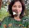 Eliane Brum em video ao ar livre vestindo blusa verde estampada