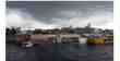 Vista de terminal fluvial com barcos e ceu carregado de chuva
